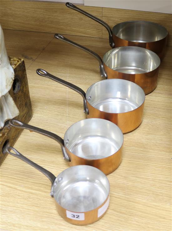 A graduated of set of five copper saucepans